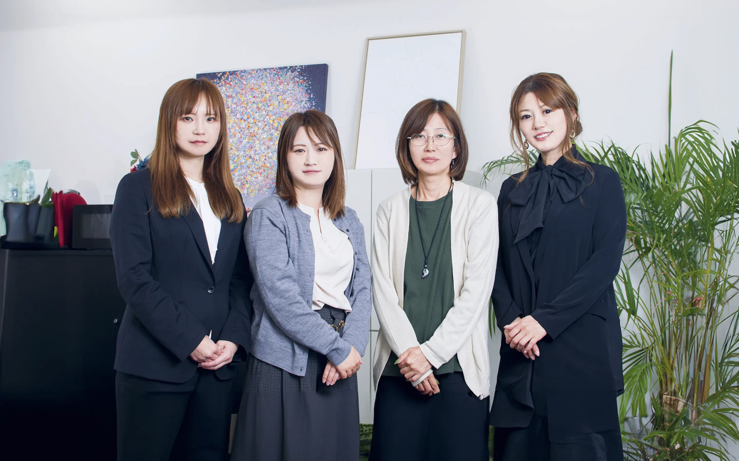 4名の女性社員が笑顔で見ている様子